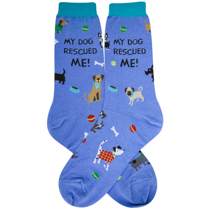 A pair of blue crew socks with a colorful pattern of various dog breeds and toys, featuring the text 'MY DOG RESCUED ME!' printed on the side.
